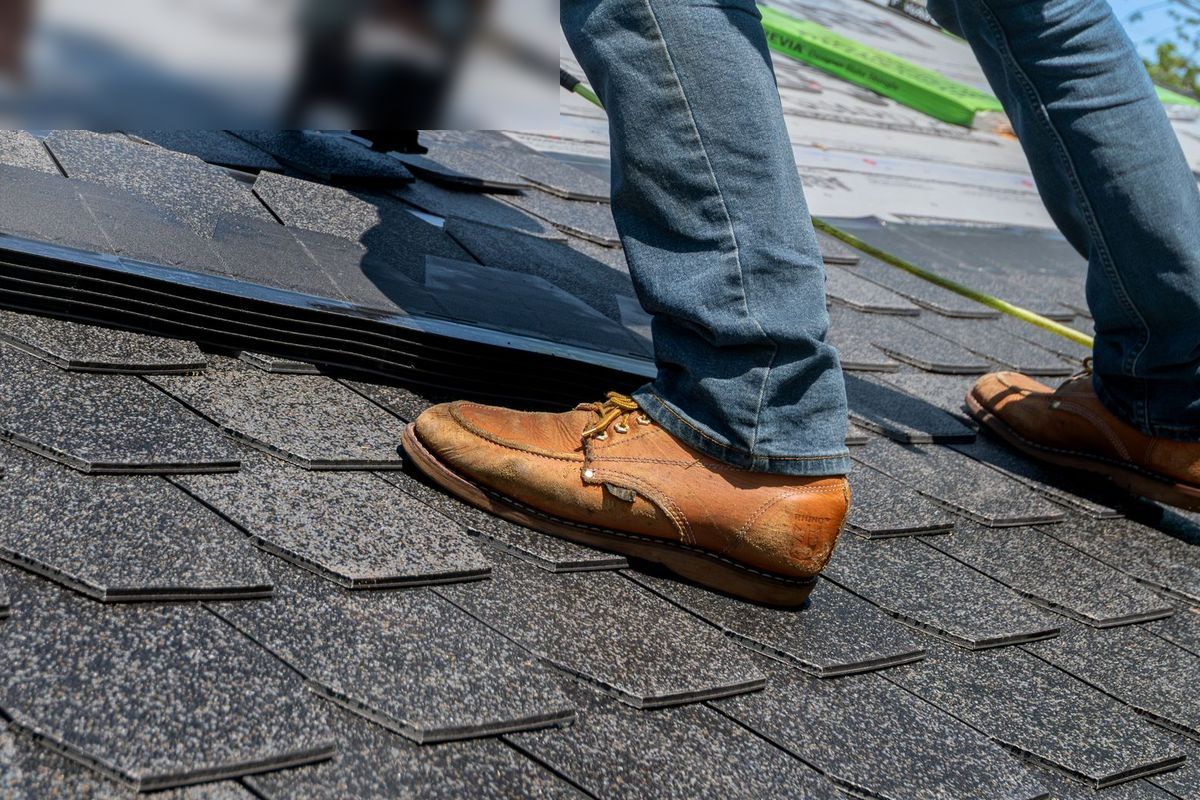 A roofer in work boots nailing new asphalt shingles into place